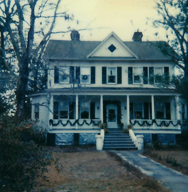 A large white house featuring a spacious porch and a welcoming front entrance