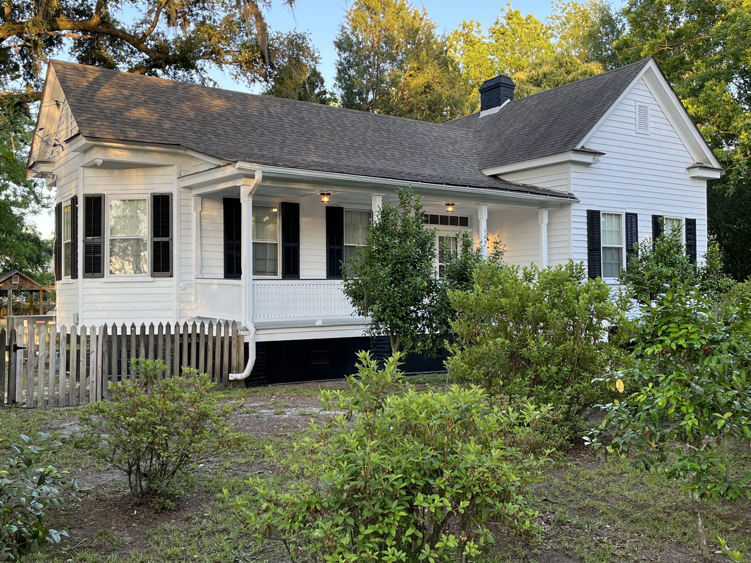 A white house featuring black shutters and a welcoming front porch